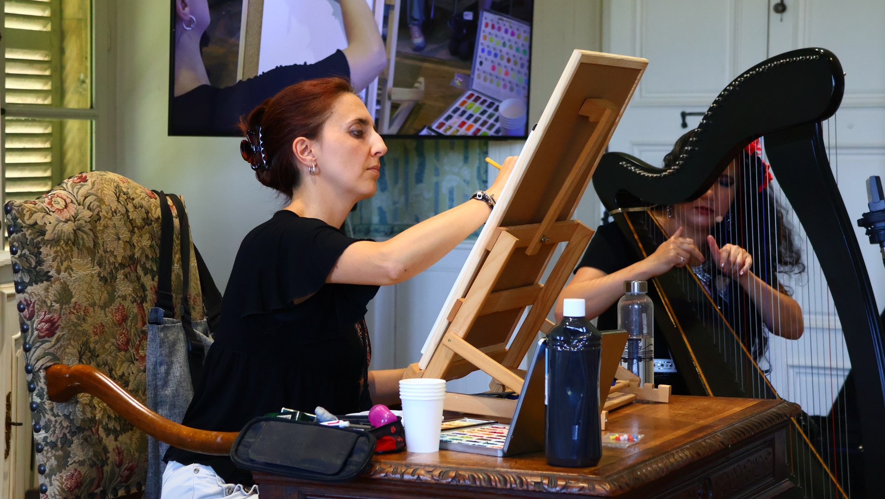 Nora Moretti dessine en direct, son dessin projeté sur grand écran, pendant qu’Ameylia Saad Wu joue de la harpe et chante